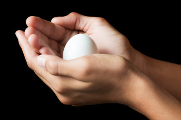 Obraz na płótnie Canvas Masculine hands holding a raw egg