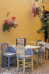 a typical Greek taverna with tables and straw chairs