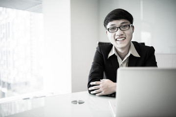 Young handsome man using laptop in his office