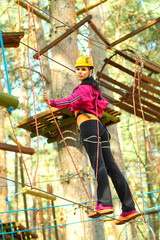 Beautiful positive brunette  engaged climbing the trees. 