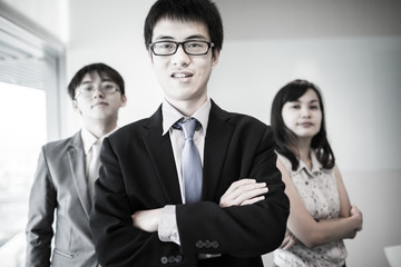 Happy business team with arms crossed at the office