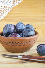 Fresh plums in ceramic bowl