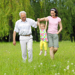 Naklejka na ściany i meble family of three generations walking in the park