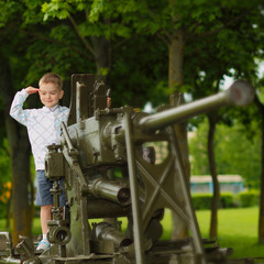 boy child explores old vintage military tank