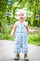 Happy toddler boy looking at bubbles