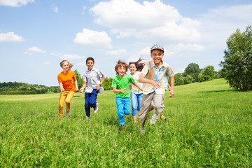 Positive kids play and run together in the field
