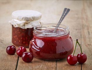 two jars of fruit jam with cherries
