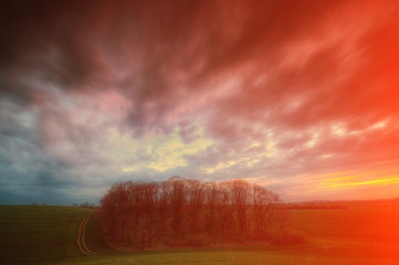 Zachód słońca nad zielonym polem z chmurami