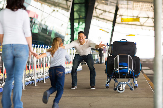 little girl running to her father at airport