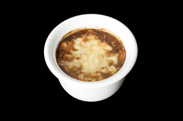 French onion soup, covered with melted cheese isolated on black