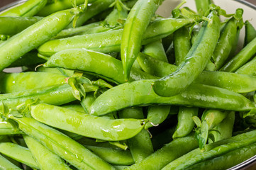 Fresh green pea pods in a bowl