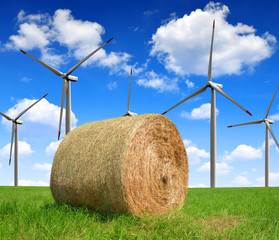 Straw bale on farmland with wind turbines