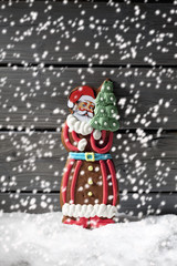 Lebkuchennikolaus auf Schnee vor Holzhintergrund