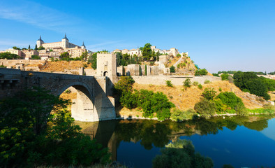 Fototapeta na wymiar Day view of Puente de Alcantara - ancient bridge in Toledo.