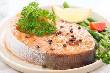 baked salmon with asparagus and lemon on plate, close-up