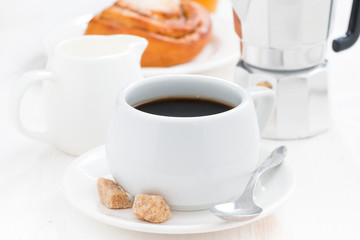 breakfast with coffee, sweet bun and cream, close-up