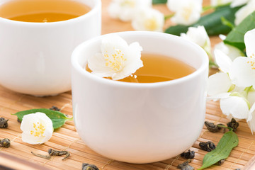 Green jasmine tea in white cups, selective focus
