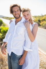 Obraz premium Attractive couple smiling at camera road side