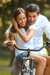 Obraz premium Happy couple cycling in the summer park