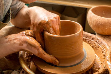 hands of a potter, creating an earthen jar