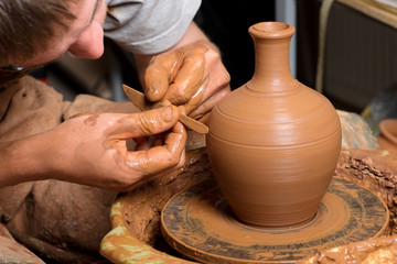 hands of a potter, creating an earthen jar