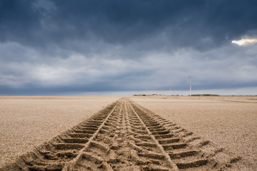 Tyre tracks on the sand of the beach