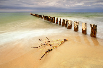 Piękna piaszczysta plaża z drewnianym falochronem