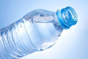 Foto op Plexiglas Open a bottle of water on blue background © Hyrma