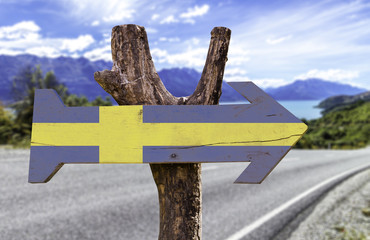 Sweden wooden sign with a landscape on background