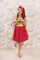 Obraz na płótnie Canvas pinup redhead girl with colorful cupcakes.