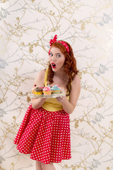 pinup redhead girl with colorful cupcakes.