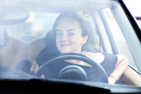Young beautiful woman at a steering wheel