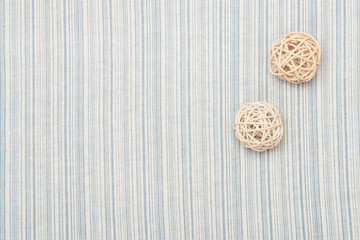 Obraz na płótnie Canvas Rattan Balls On Natural Linen Striped Textile