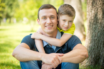 Little son hugging his father in the park