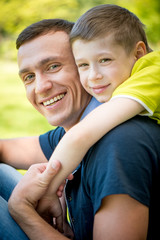 Happy father and son hugging in the park