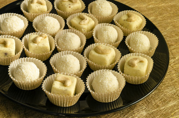 White chocolate homemade truffles with cashew on black plate