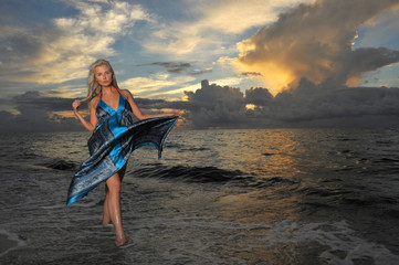 Model posing in beach dress at early morning sunrise