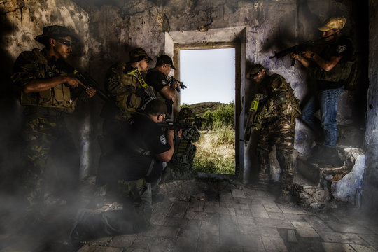 Airsoft group team in daytime action hiding