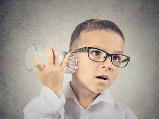 Curious boy listening with glass cup to a conversation  
