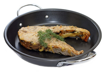 Fried fish with sprig of dill in frying pan