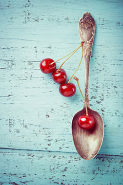 Vintage Spoon And Cherry Berries On Old Wooden Board