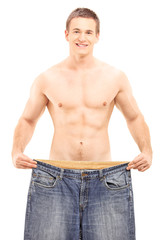 Shirtless weightloss male showing his old pair of jeans