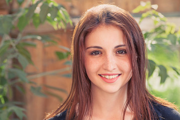 Smiling redhead teen. Front view smiling girl plank  with leaves