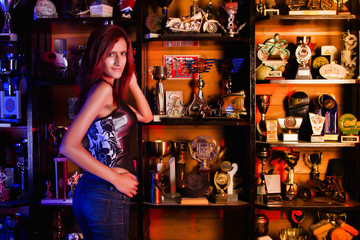  Biker girl standing in front of many trophies.