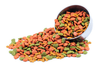 Silver bowl full and overflowing with dog food bits on a white b