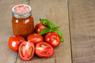 Jar of tomato sauce with tomatoes and basil