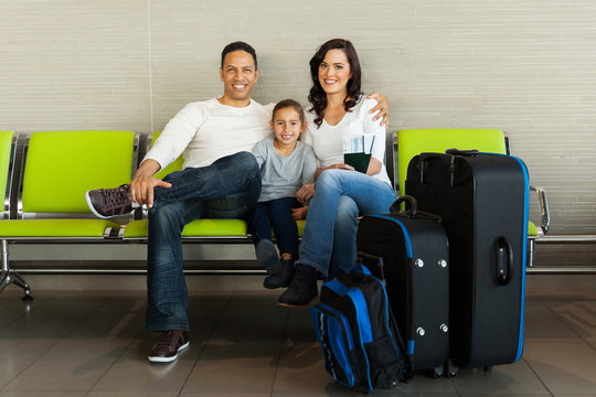 family with luggage waiting at airport