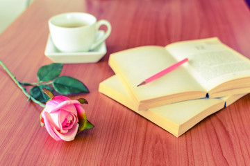 Fototapeta na wymiar pink rose with book and coffee