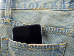 Phone in a back pocket of a denim jeans as a background