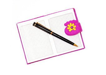 Open notebook in a purple cover with a black ballpoint pen on a